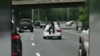Man clinging to back of car on fast-moving interstate